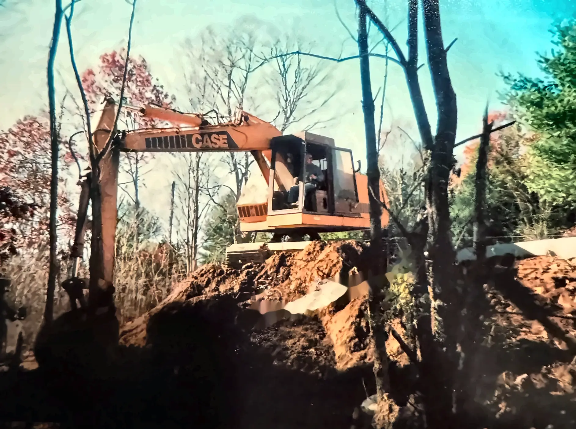 Mike Terwilliger running the company's Case excavator on a wooded Connecticut job site
